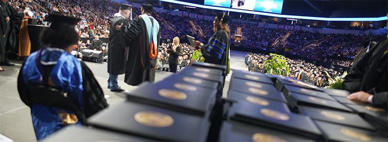 2023 Commencement Recap - Stacks of diploma covers wait to be handed out on the Cable Dahmer stage.